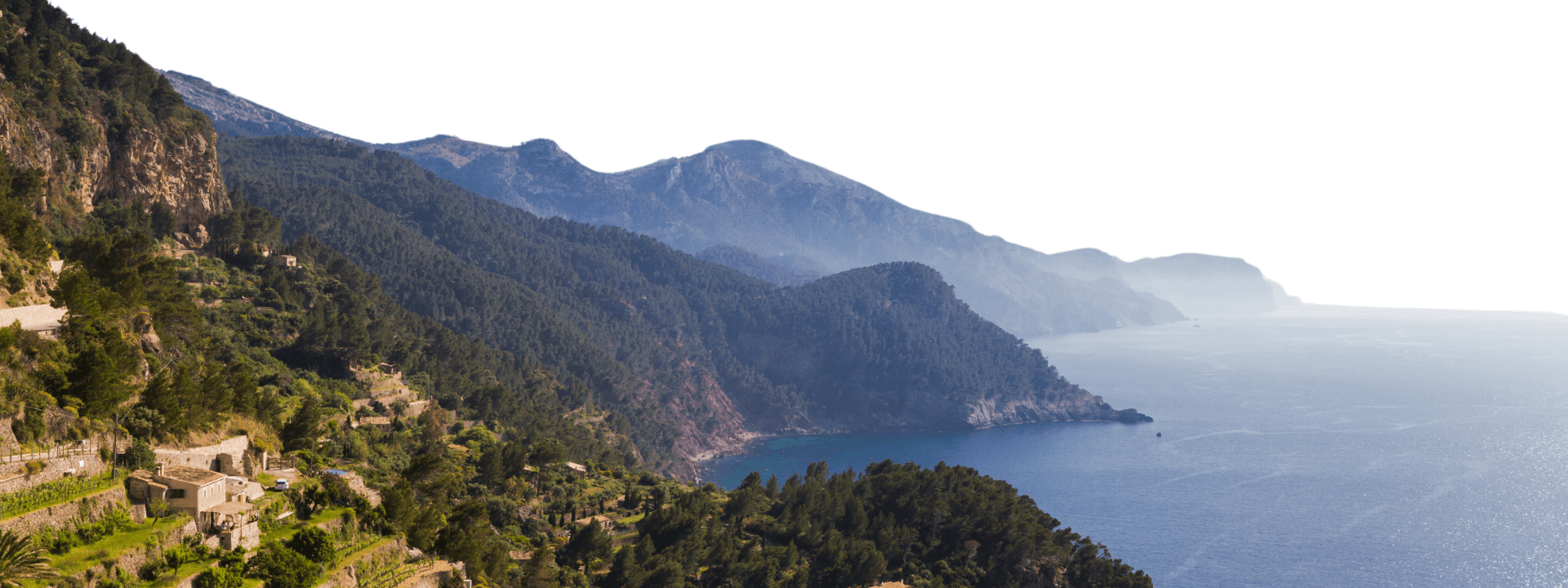 Stunning coastal view of the Serra de Tramuntana mountains in Mallorca, with forested hillsides descending to the Mediterranean Sea.