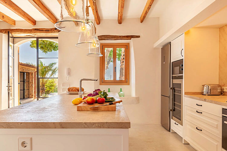 Bright rustic-style kitchen with wooden beams, island worktop, and modern appliances