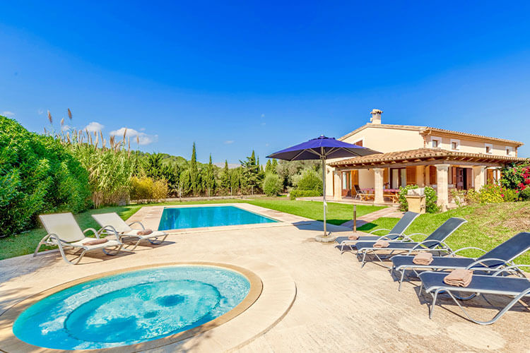 Luxury villa with large swimming pool, jacuzzi, sun loungers and a shaded patio.